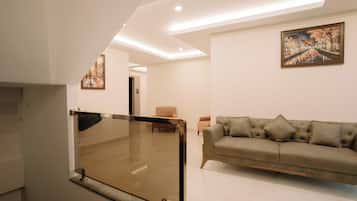 Una sala moderna con un sofá, un cuadro y un panel de vidrio.