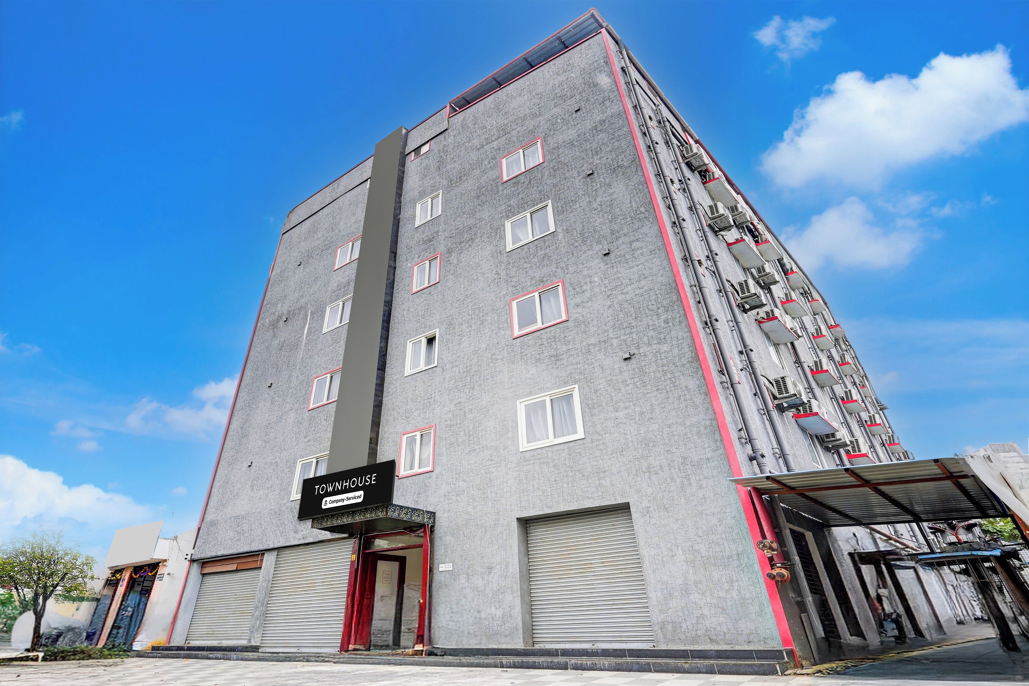 A multi-story building with a sign indicating it is a company-serviced townhouse.