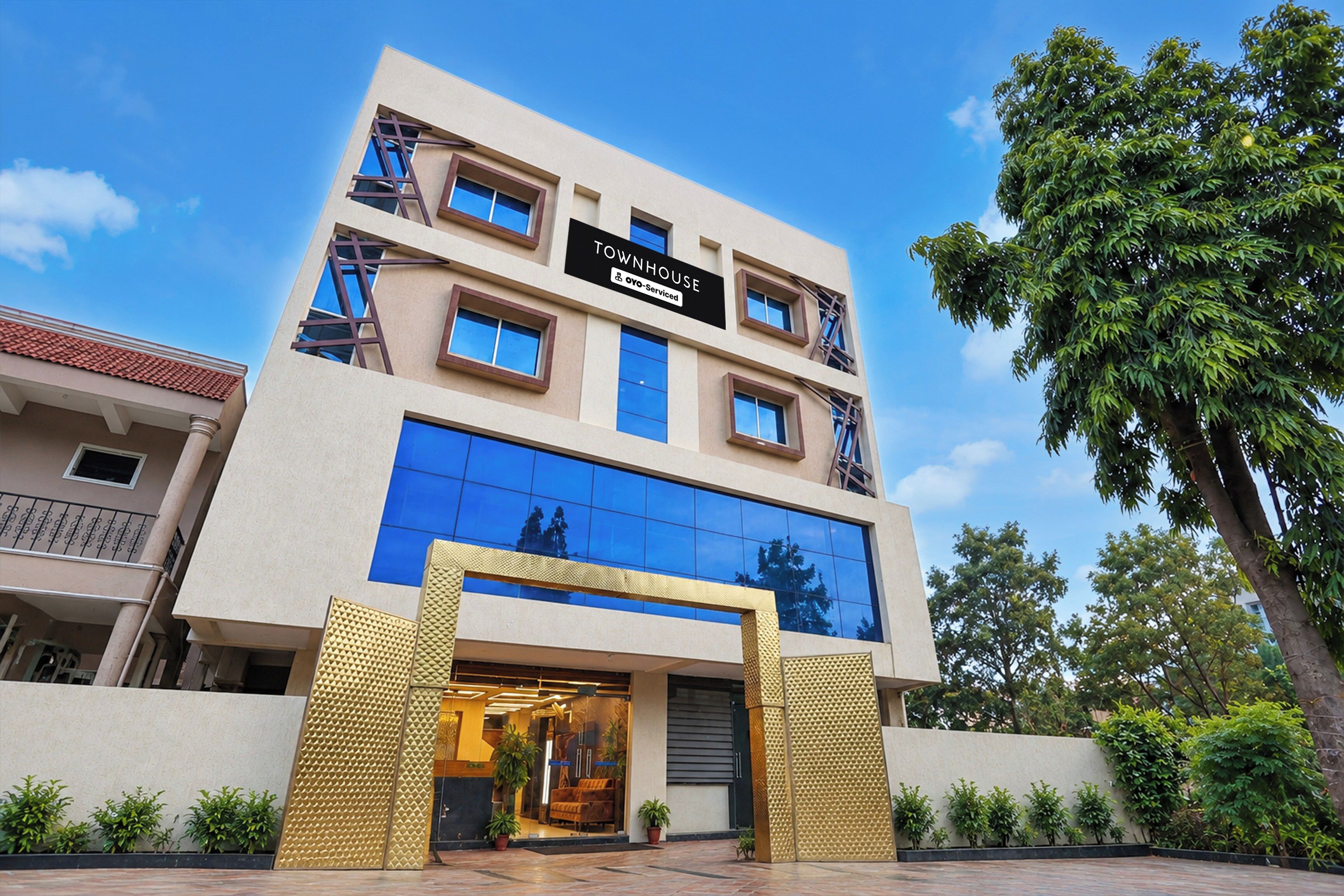 A multi-story hotel with a sign reading 'TOWNHOUSE OYO-Service'.