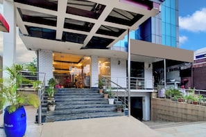 Entrada d'un edifici modern amb una escalinata coberta que condueix a una zona de vestíbul.