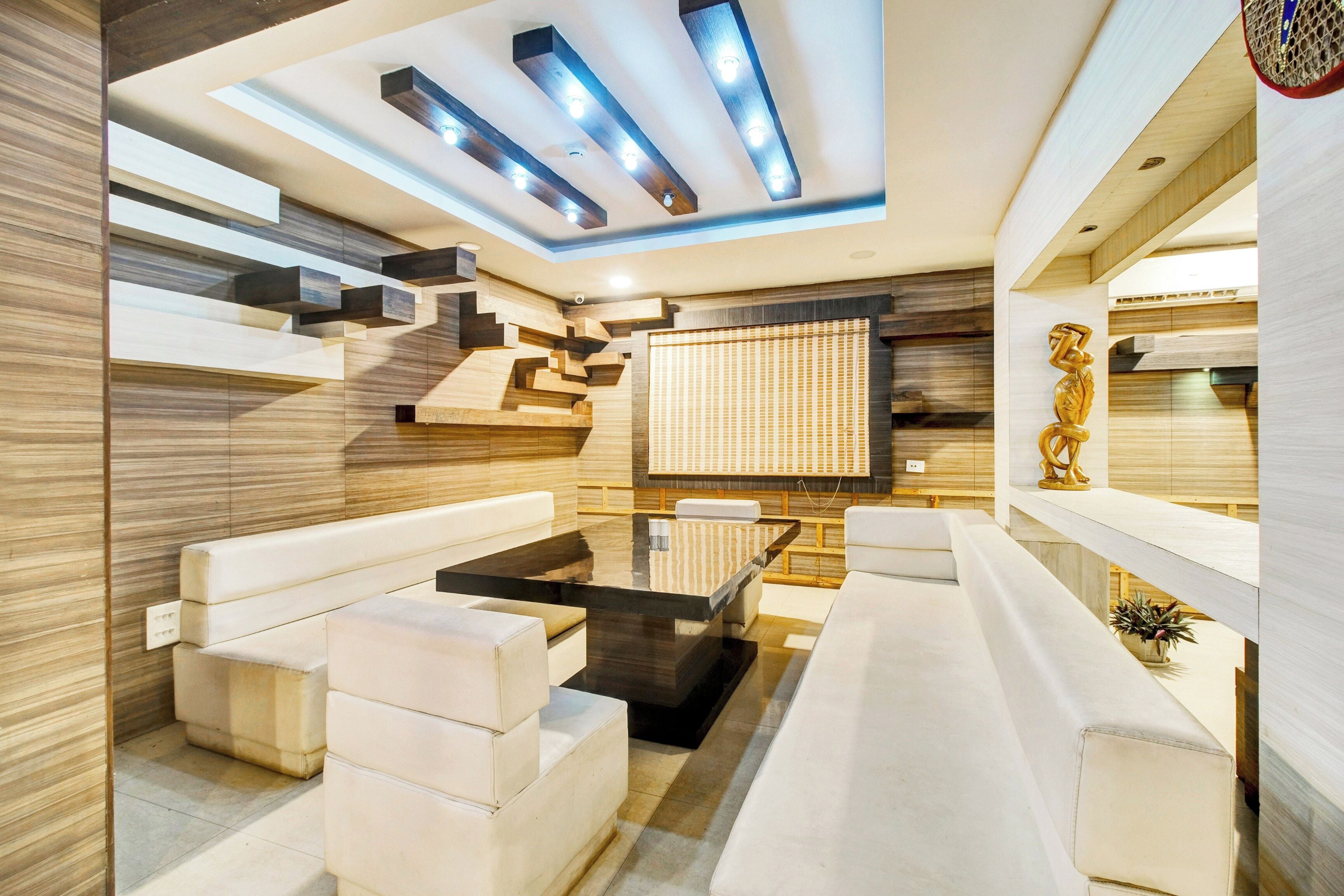 Un interior moderno con un sofá modular, una mesa de centro y una escultura decorativa.