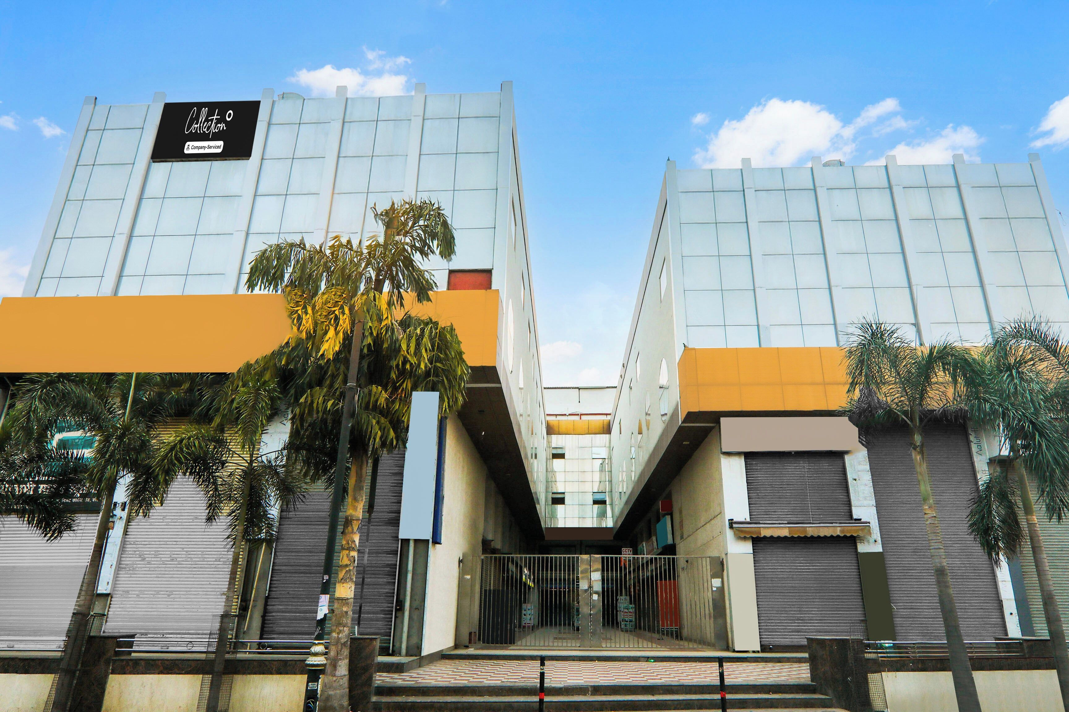 Un edificio moderno con fachada de vidrio, una entrada central y un letrero que indica que es un lugar de servicios para empresas.