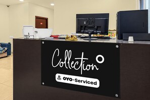 Una mesa de recepción con un cartel que dice 'Collection' y 'Oyo-Serviced'.