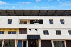 Un edificio de varios pisos con un letrero que indica un conjunto de apartamentos con servicios.