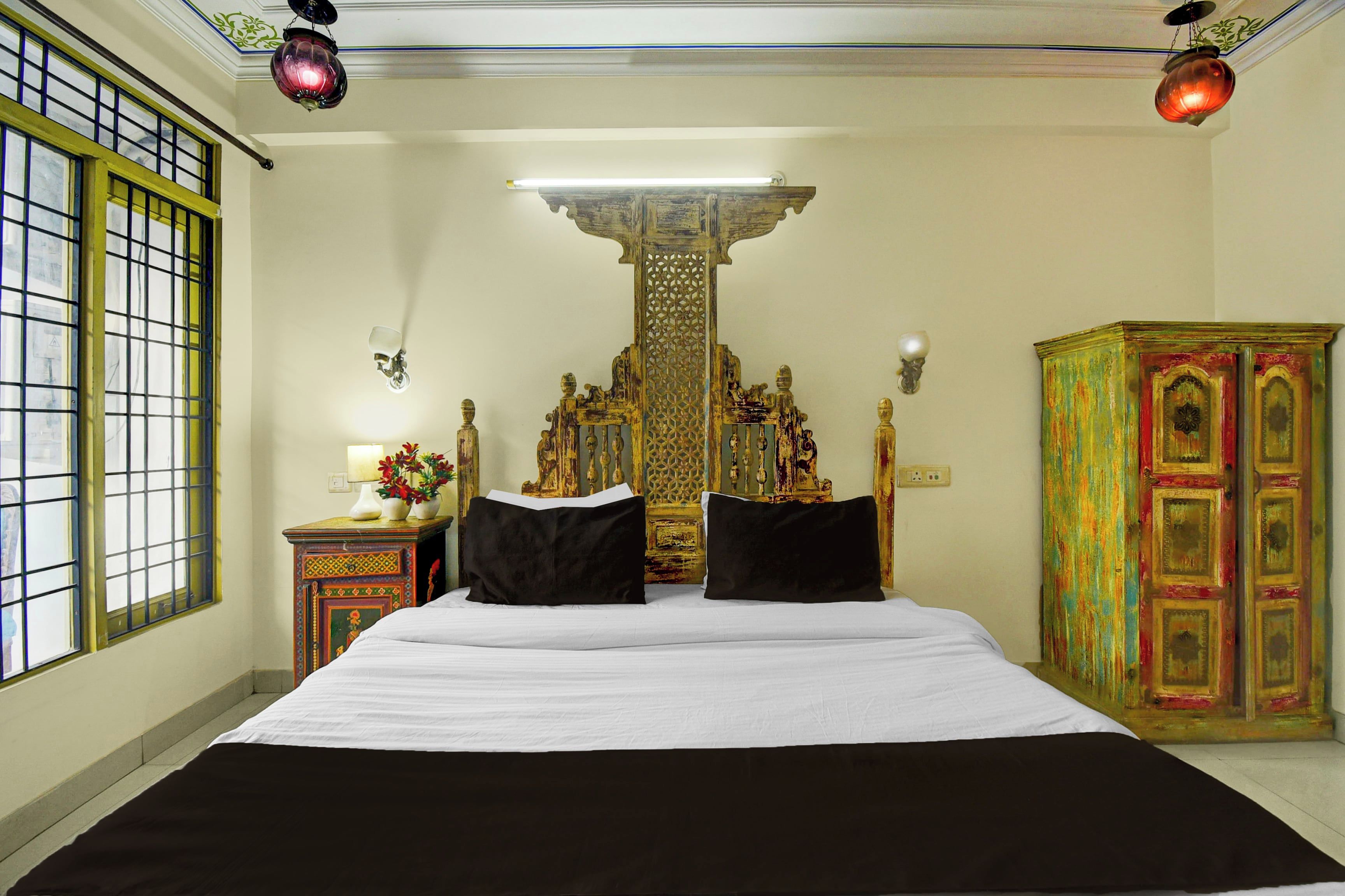 Una habitación con una cama, una mesita de noche, una lámpara y un armario.