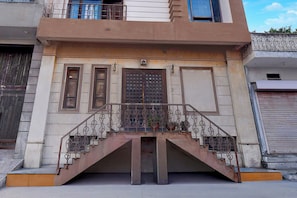 A building with a central staircase, a metal railing, and a decorative door. - Collection O Jal Mahal Jaipur (Jaipur)