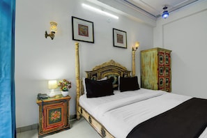 A bedroom with a bed, a nightstand with a lamp, a telephone, and a cabinet. - Collection O Jal Mahal Jaipur (Jaipur)
