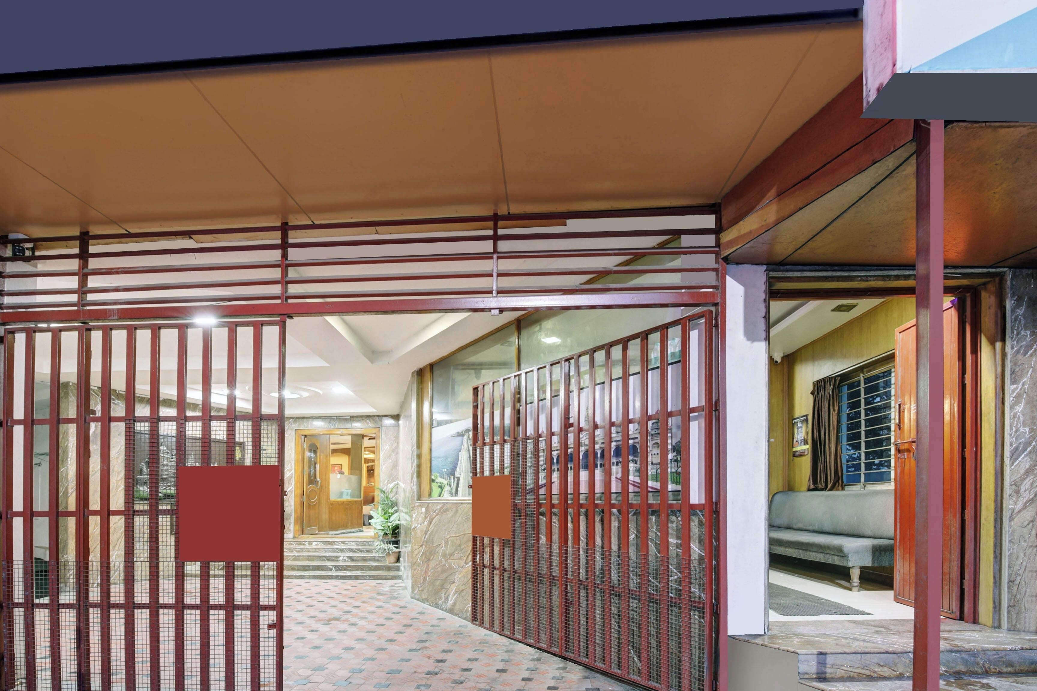 A gated entrance with a tiled pathway leading to a building.