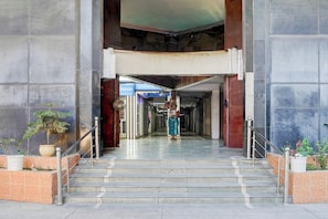 A building entrance with a staircase leading to a covered area.