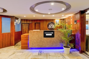A reception desk with a sign indicating 'Company Serviced' and a logo above it.