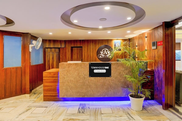 A reception desk with a sign indicating 'Company Serviced' and a logo above it.