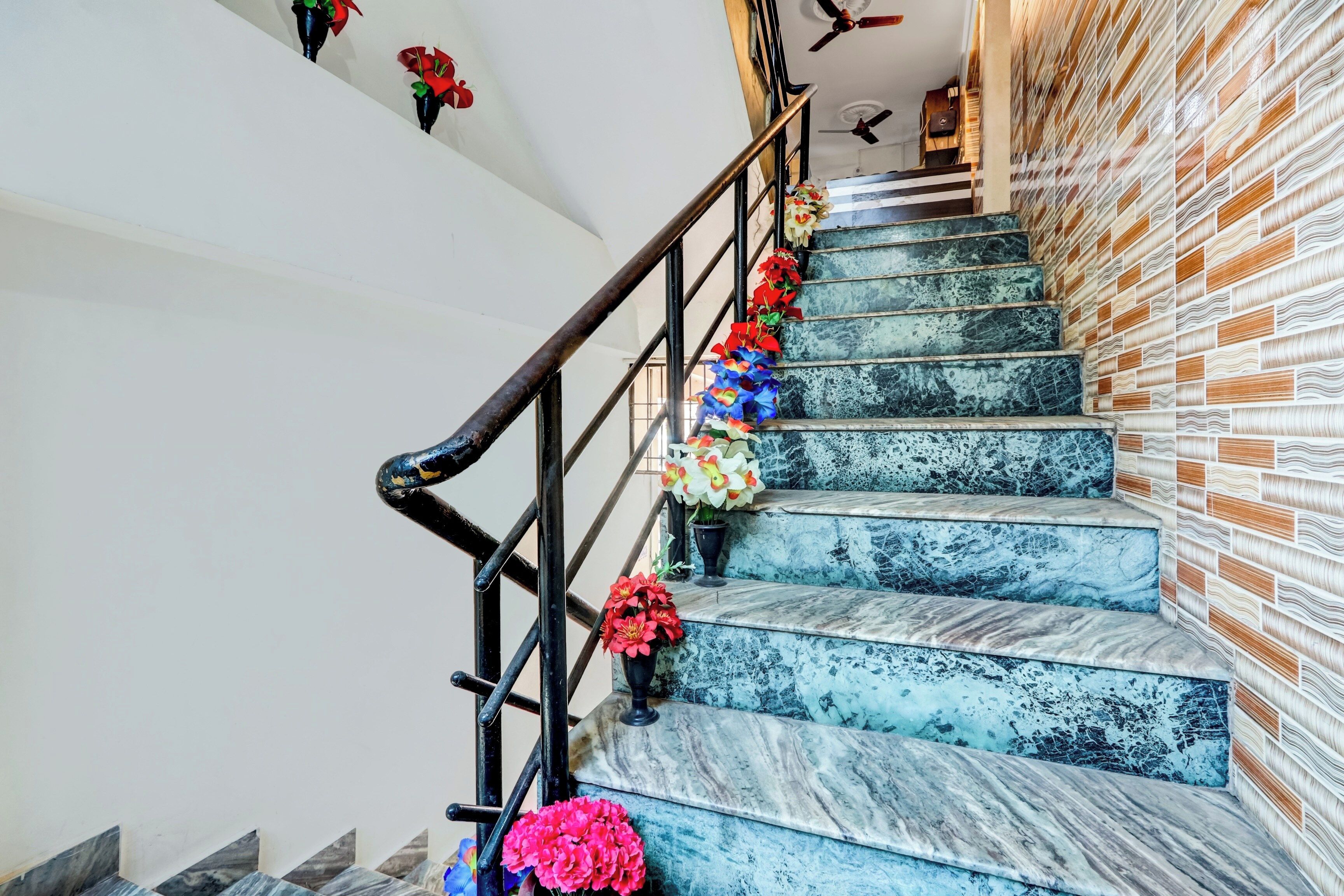 Un escalier avec des marches recouvertes de marbre et un mur en briques sur un des côtés.