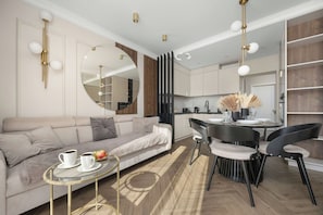 A modern living room with a sofa, coffee table, and dining area.