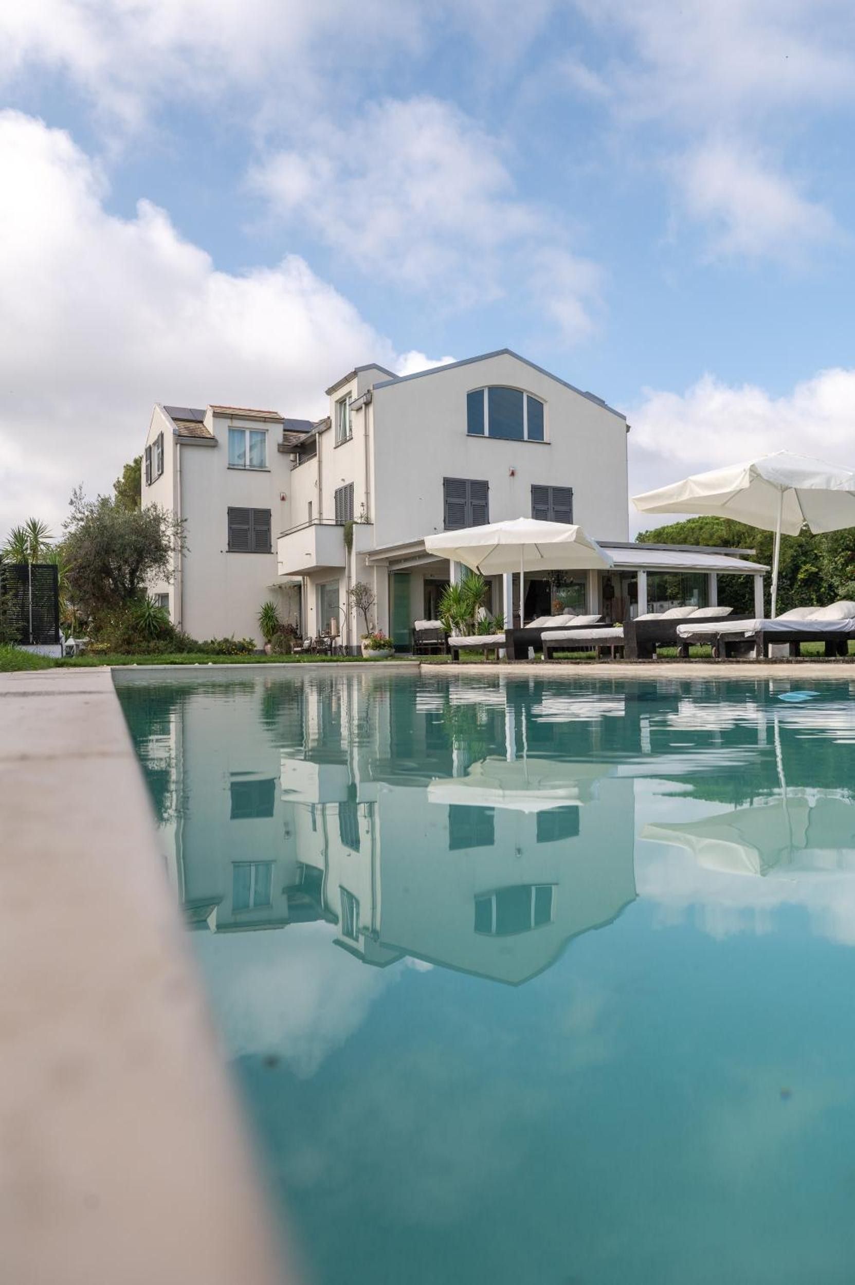 Un bâtiment moderne doté d’une piscine, d’un espace extérieur aménagé et offrant une vue sur un ciel dégagé.