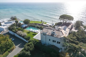 Ein Wohnhaus mit Swimmingpool, Tennisplatz und Meerblick.