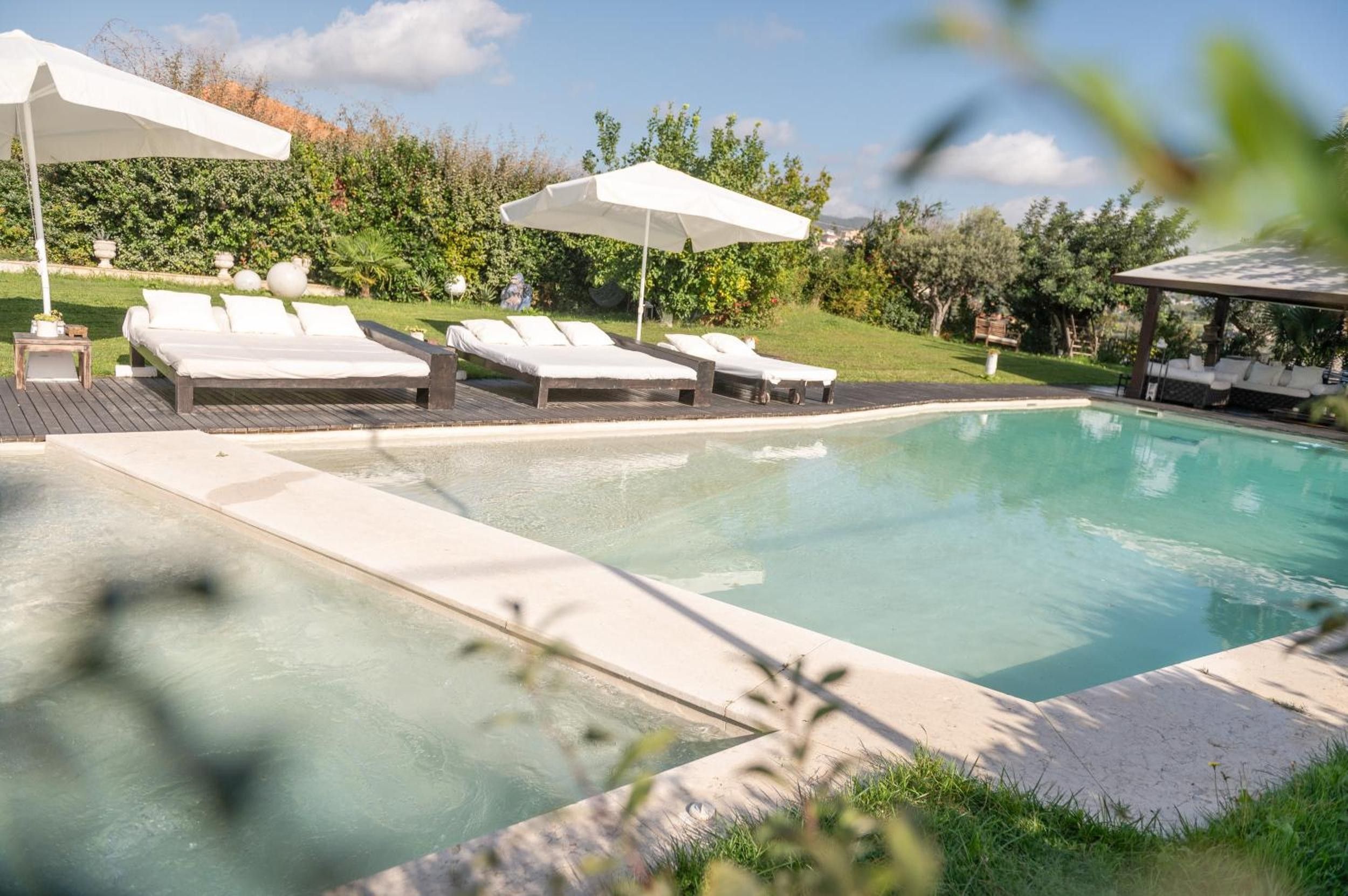 Ein Poolbereich mit Liegestühlen und Sonnenschirmen.