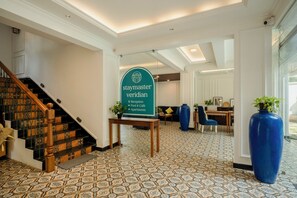 Et receptionområde med skilt, der angiver faciliteter som reception, pool og café, samt lejligheder.