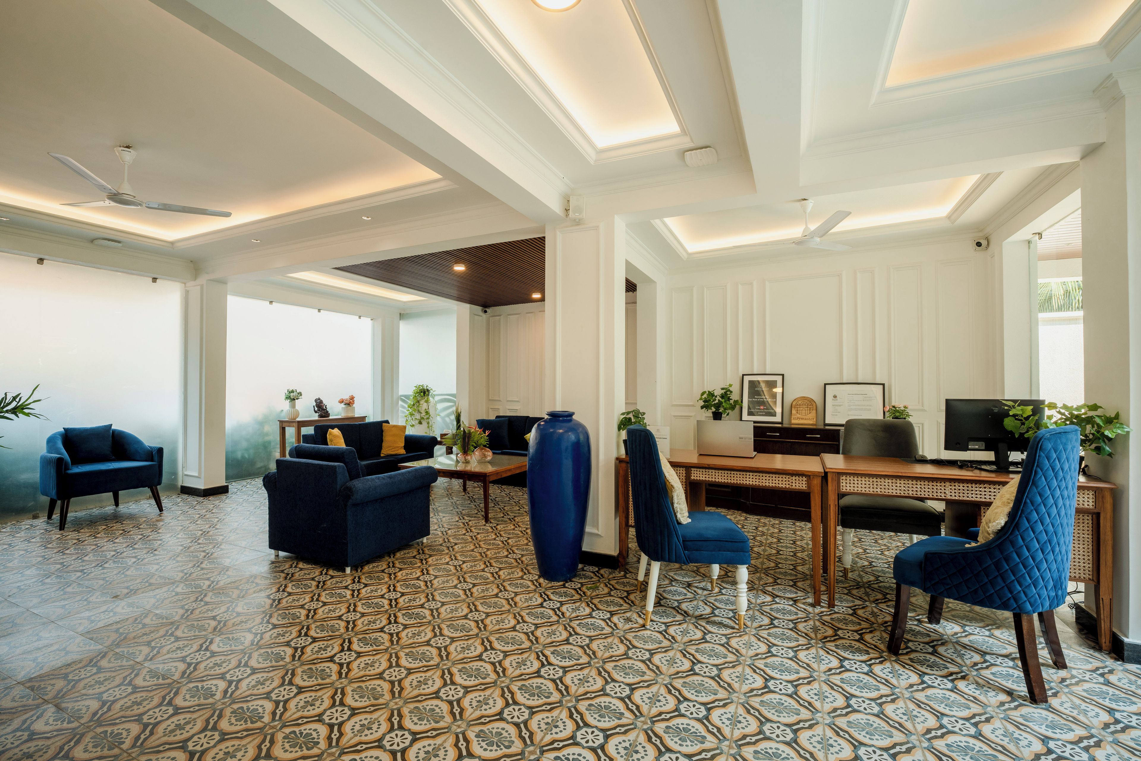 Amplia sala de estar con piso estampado, muebles modernos y ventilador de techo.