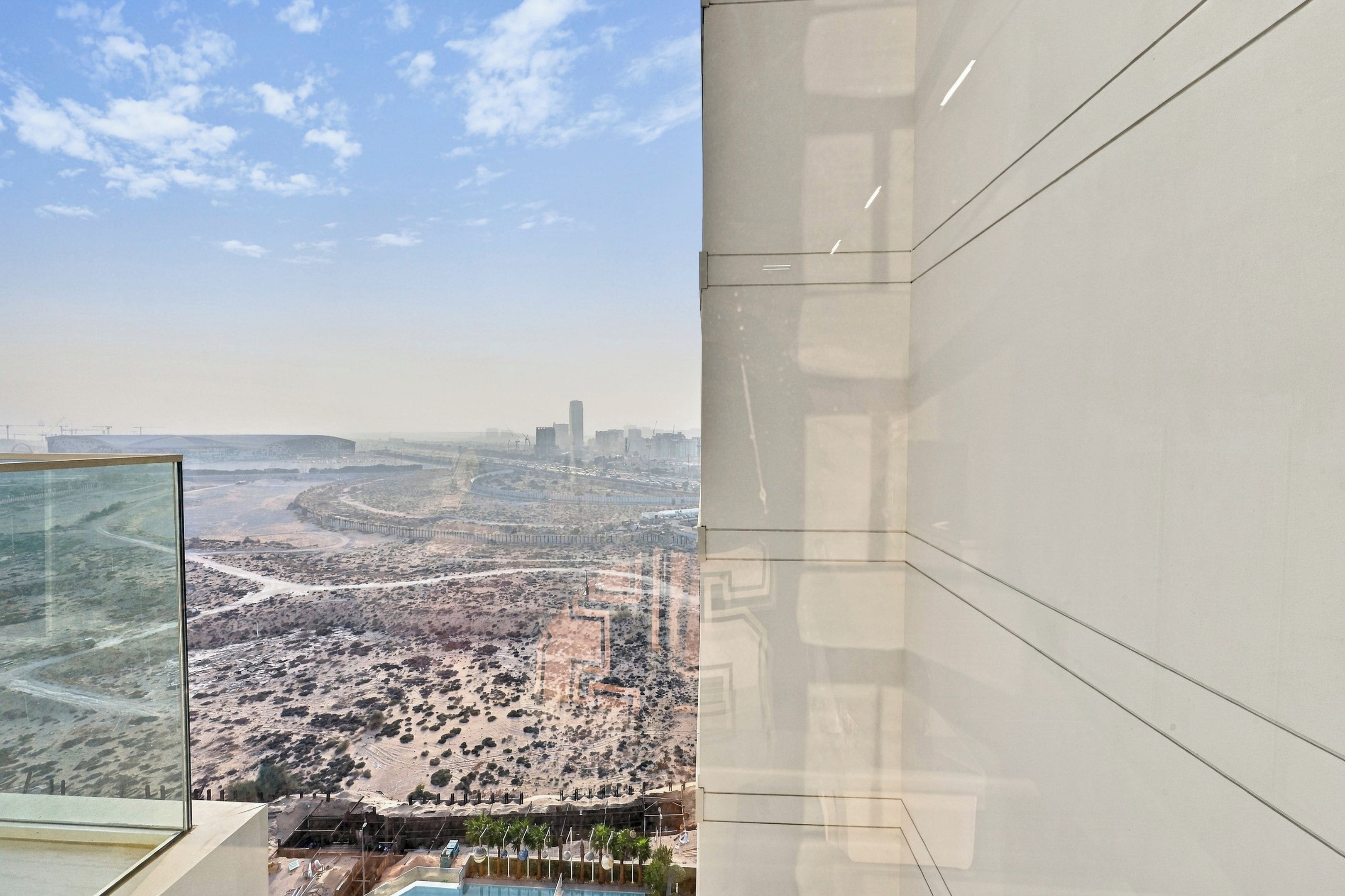 A high-rise building with a view of a desert landscape and a city skyline.