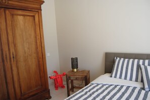 A bedroom with a bed, a nightstand, a lamp, and a wardrobe. - Holiday Home 'Villa La Chanterelle' with Mountain View, Wi-Fi and Air Conditioning (Entrechaux)