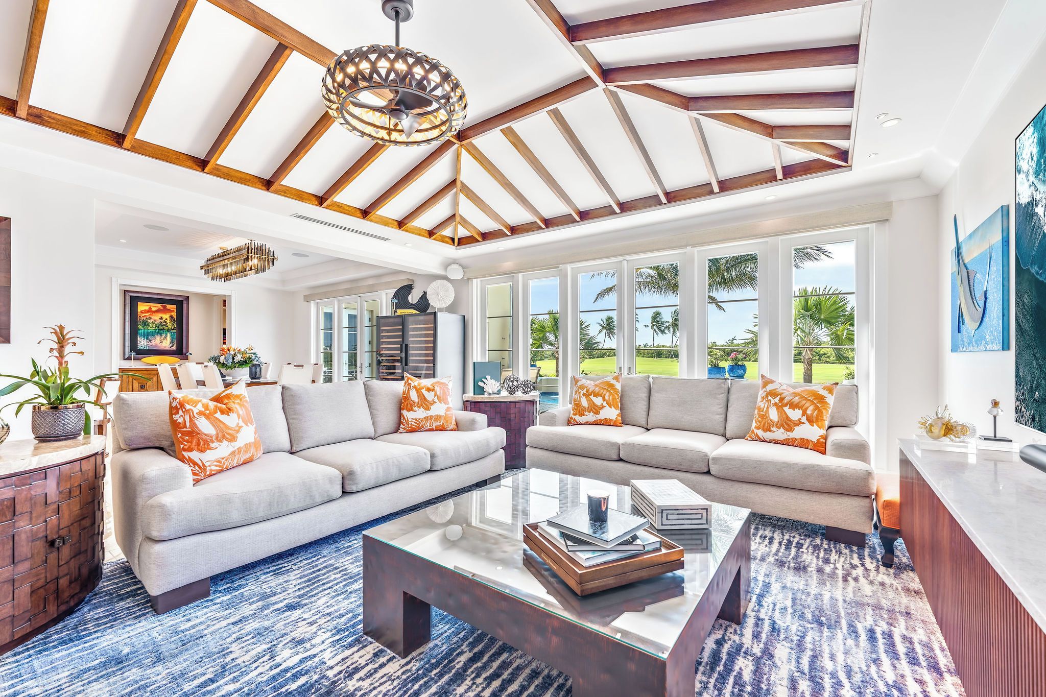 A spacious living area with a high ceiling, large windows, and a modern interior design.
