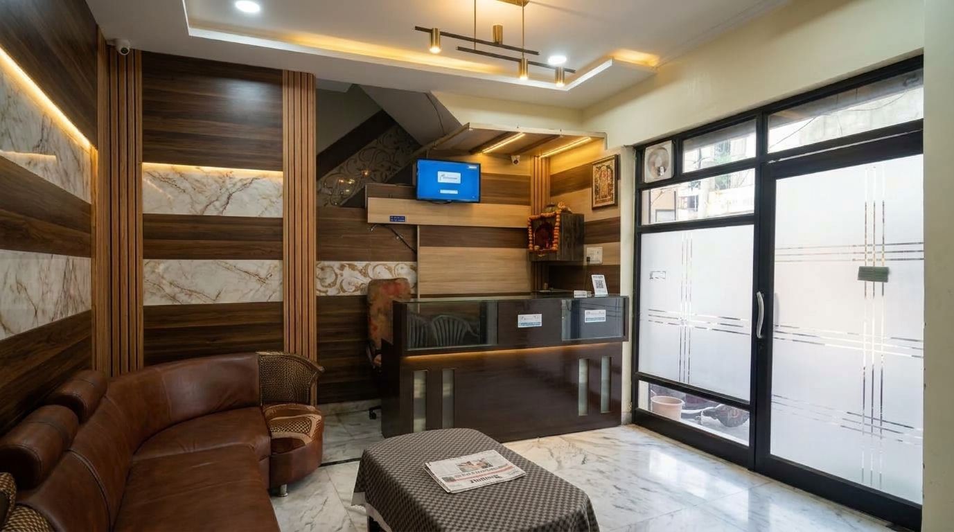 Un hall d’hôtel avec un comptoir d’accueil, un canapé en cuir marron et un téléviseur.