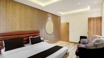 A modern bedroom with a large bed, a wooden headboard, a round mirror, a wardrobe, and a zebra-patterned chair.
