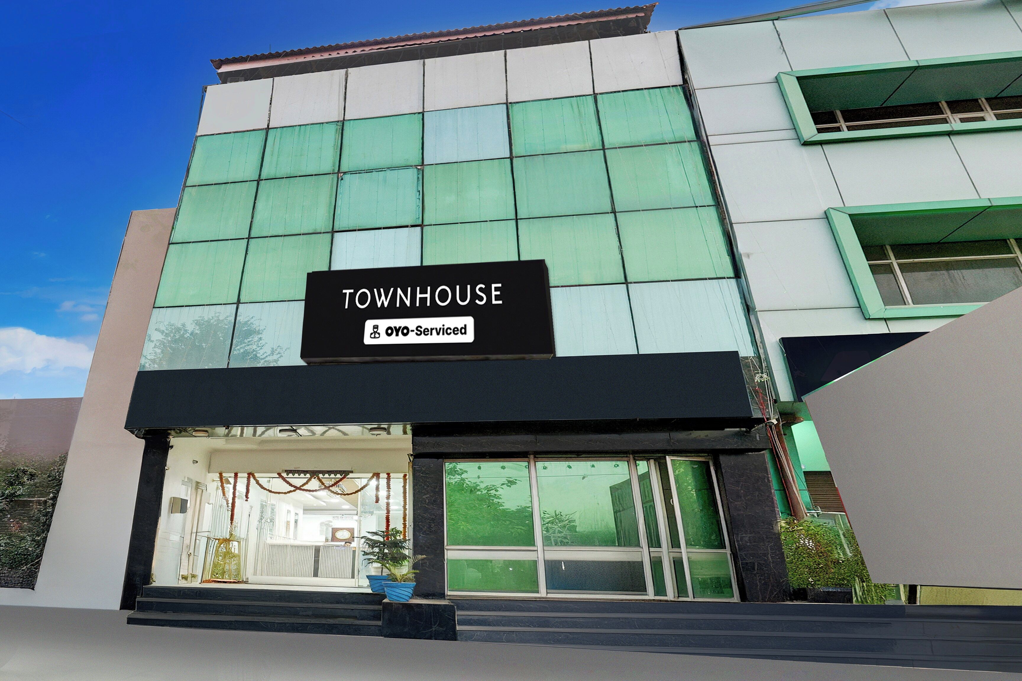 Un edificio con un cartel que dice 'TOWNHOUSE' y 'OYO-Serviced'.