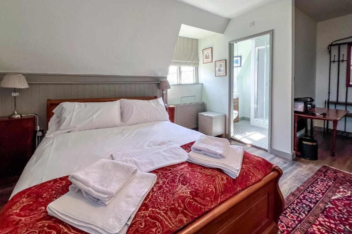 Een slaapkamer met een bed, een radiator, een raam en een deur naar een balkon.
