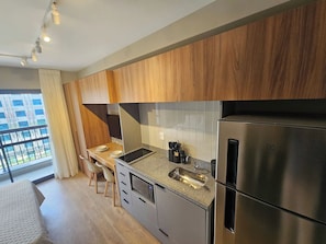 Eine moderne Küche mit einem Edelstahlkühlschrank, einem Einbauofen und einer Arbeitsplatte aus Granit.