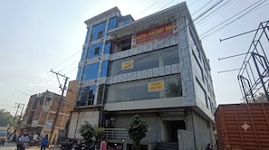 A multi-story building with a sign for a hotel named 'HOTEL HOLIDAY INN' indicating rooms for rent. - Hotel O Holiday Inn (Hyderabad)
