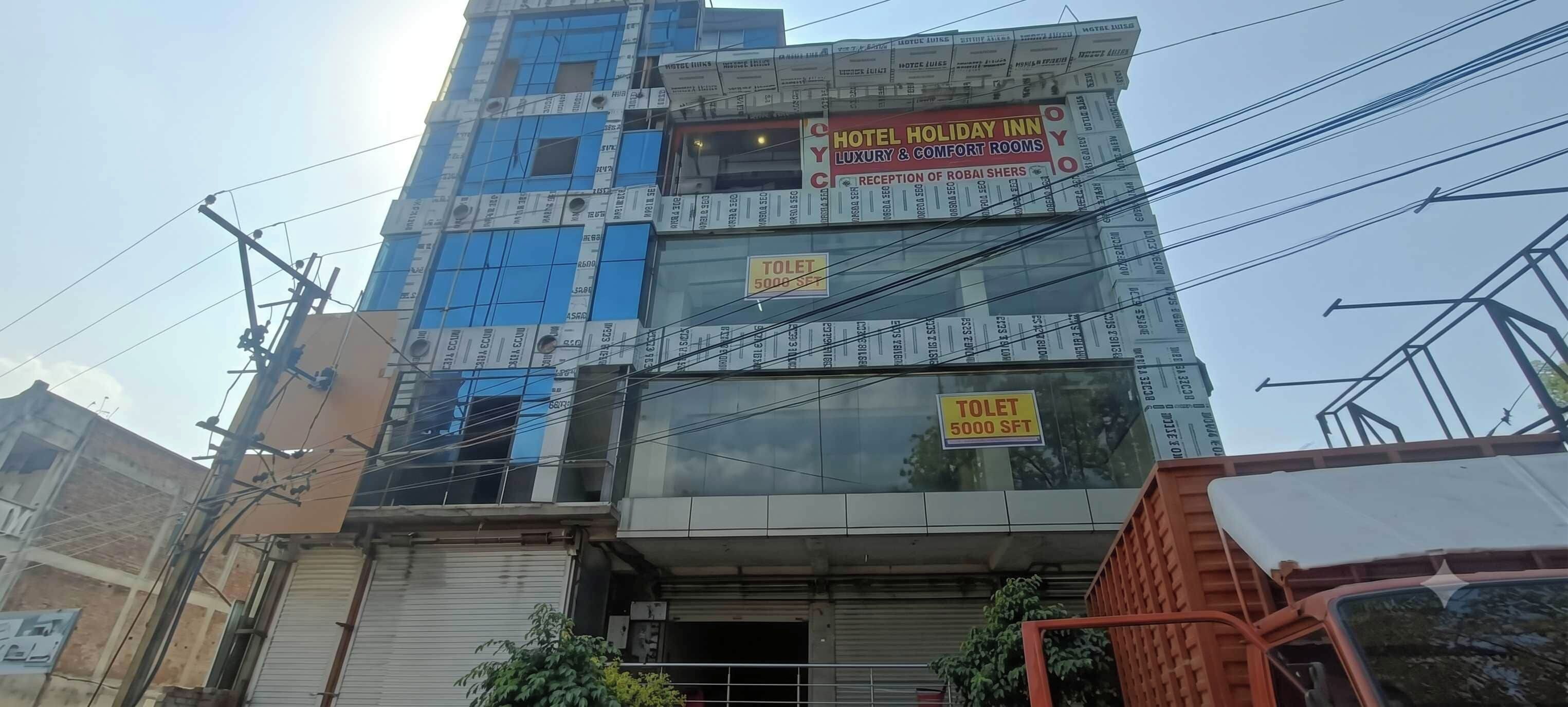 Un edificio de varios pisos con señalización de hotel, habitaciones de lujo y confort, y recepción de Robai Shers.