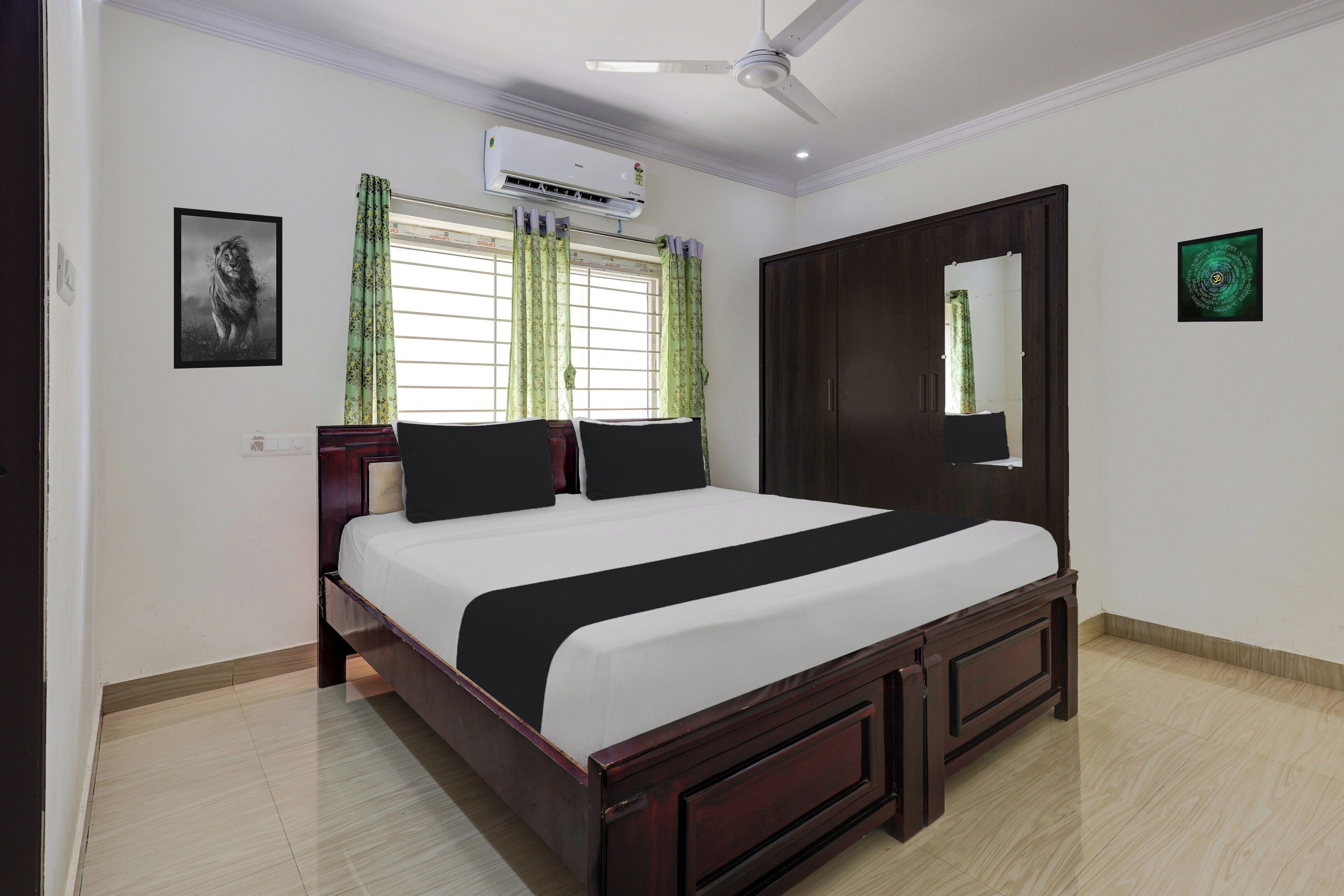 A bedroom with a bed, a ceiling fan, an air conditioning unit, a window with curtains, and a wardrobe.