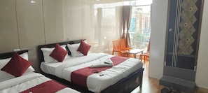 A hotel room with two beds, a balcony with orange chairs, and a view of the city. - Hotel O NAIK's RESIDENCY (Hyderabad)
