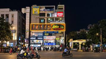 A multi-story building with various commercial establishments including a gym, electronics store, and a hotel.