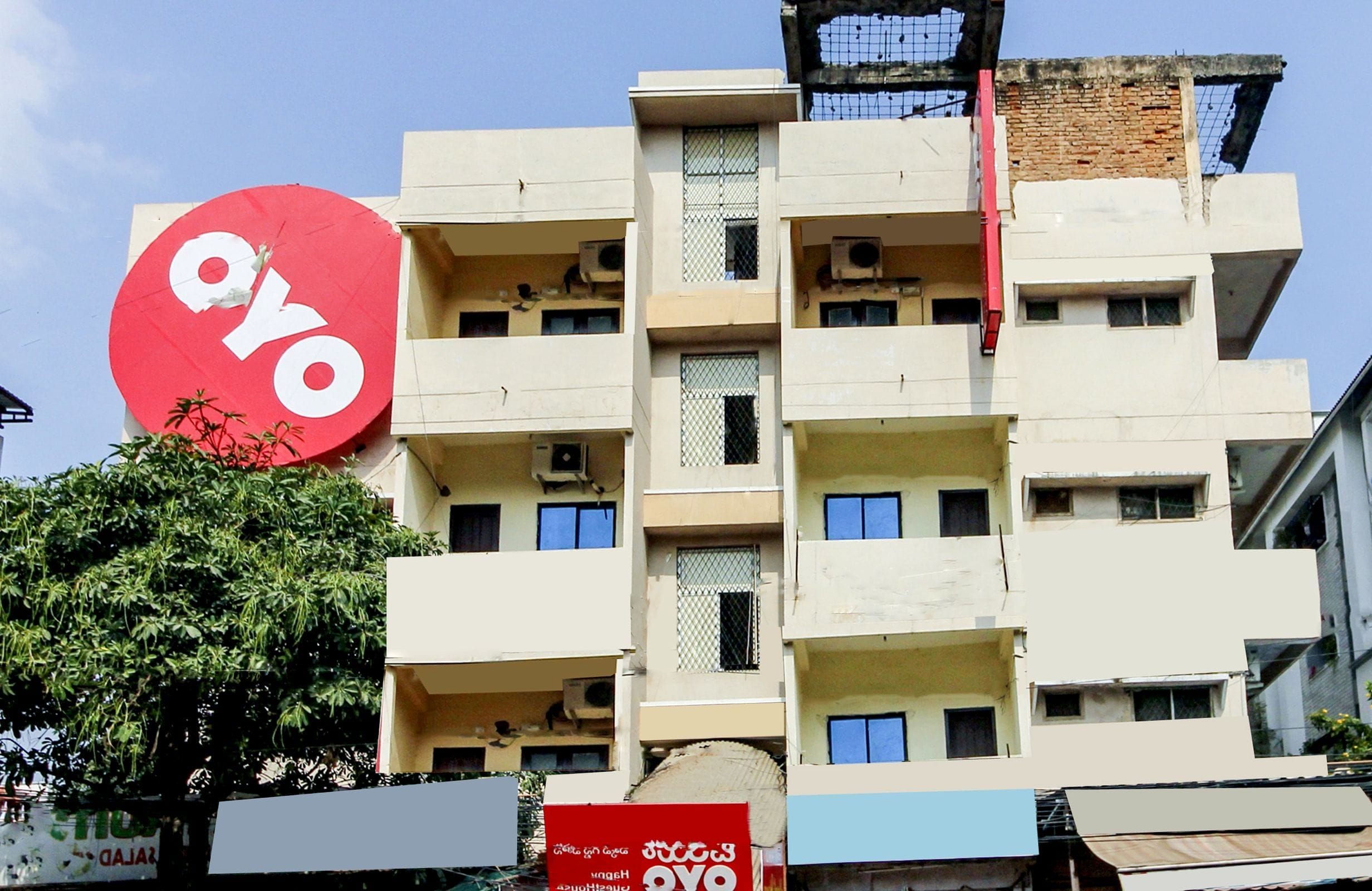 A multi-story building with a prominent red circular sign with the letters 'oyo' on it.