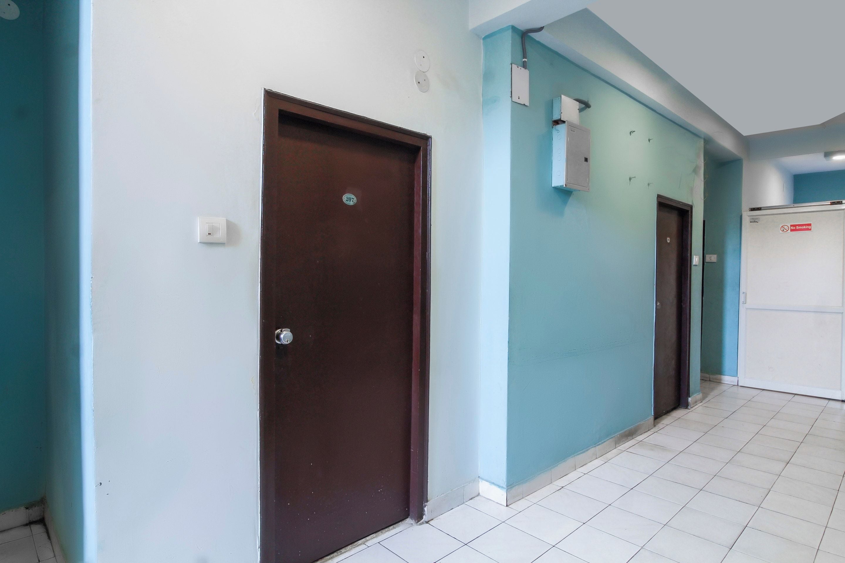 A hallway with two doors, one brown and one white, leading to rooms.