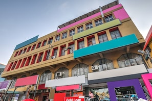 Un edifici d'àmbit urbà amb façana plana, grans finestres i diferents senyalitzacions.