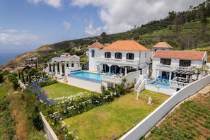 A large, two-story house with a swimming pool, surrounded by a well-maintained garden and a view of the sea. - Blue Sea Tower plus Guest Villa  (CALHETA)