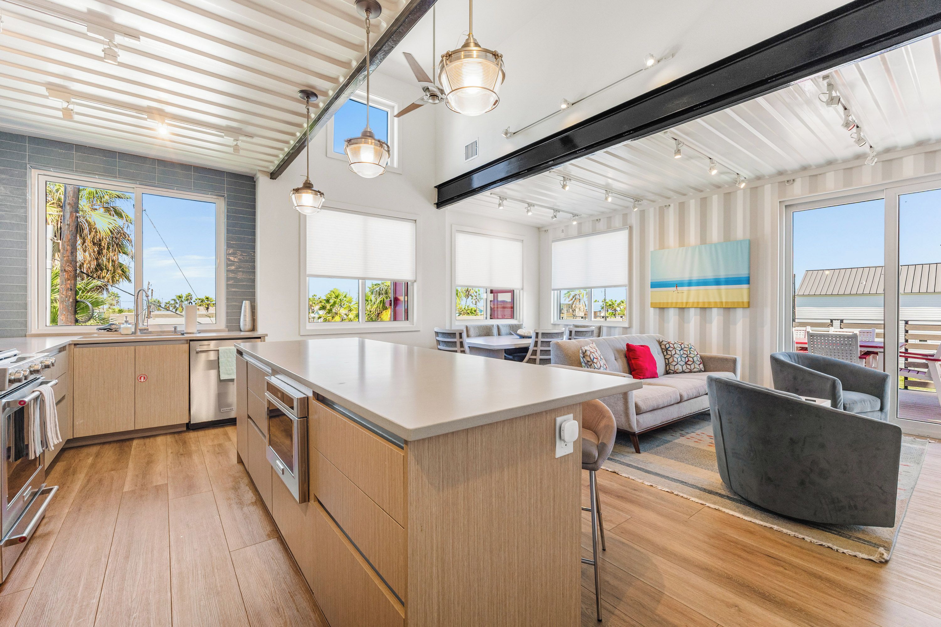 Una cocina moderna con una isla grande, armarios de madera y electrodomésticos de acero inoxidable.