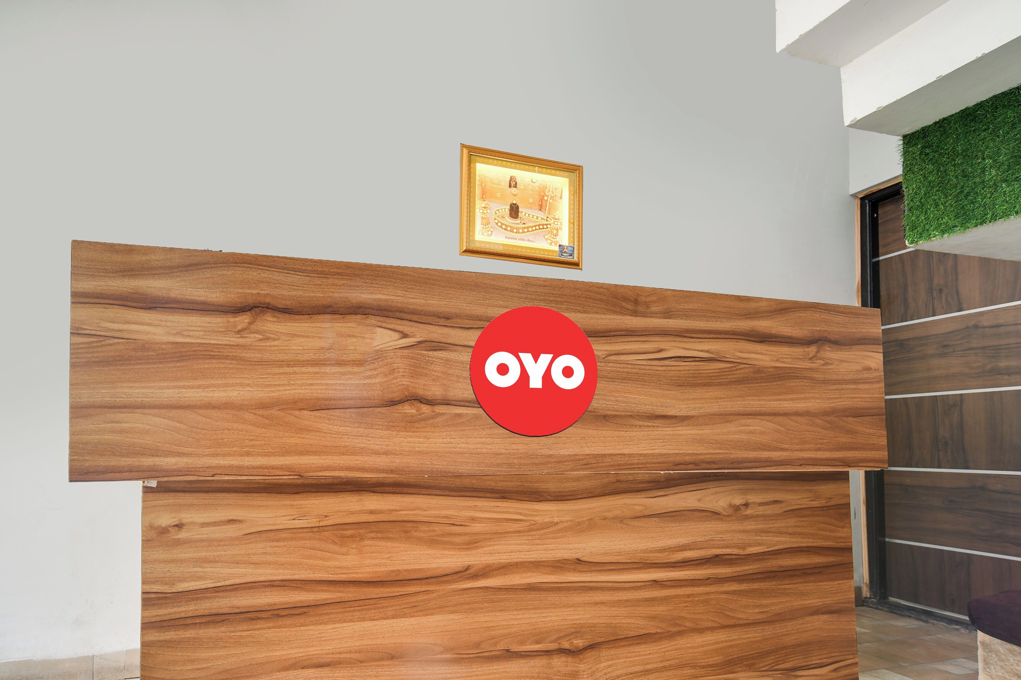 A reception desk with a wooden finish and a red circular logo.