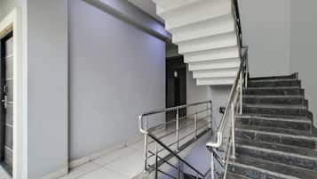 Una escalera moderna con barandilla de metal que sube a un nivel superior.