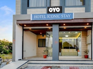 Entrada de un hotel con un letrero que dice 'HOTEL ICONIC STAY' y el logotipo 'OYO'.