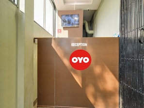 A reception area with a sign indicating 'RECEPTION' and the logo 'OYO'. - Hotel O BR Greens (Indore)