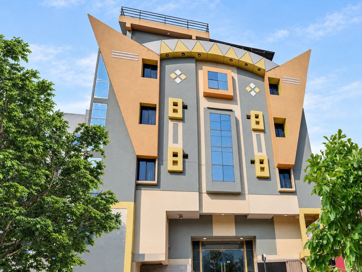 Un edificio moderno con un diseño arquitectónico único que presenta formas geométricas y una combinación de colores amarillo y gris.