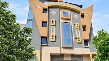 Un edificio moderno con un diseño arquitectónico único que presenta formas geométricas y una combinación de colores amarillo y gris.