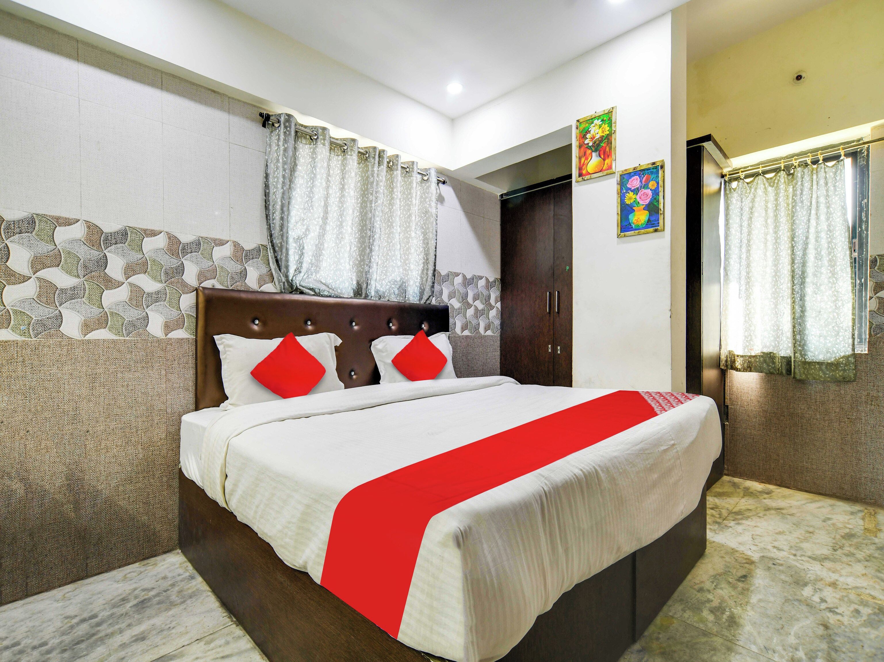 Una habitación de hotel con cama, cortinas, armario y un diseño decorativo en la pared.