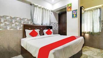Una habitación de hotel con cama, cortinas, armario y un diseño decorativo en la pared.