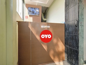 A reception area with a 'RECEPTION' sign and a 'YOYO' logo, a 'NO SMOKING' sign, and a security camera. - Hotel O BR Greens (Indore)