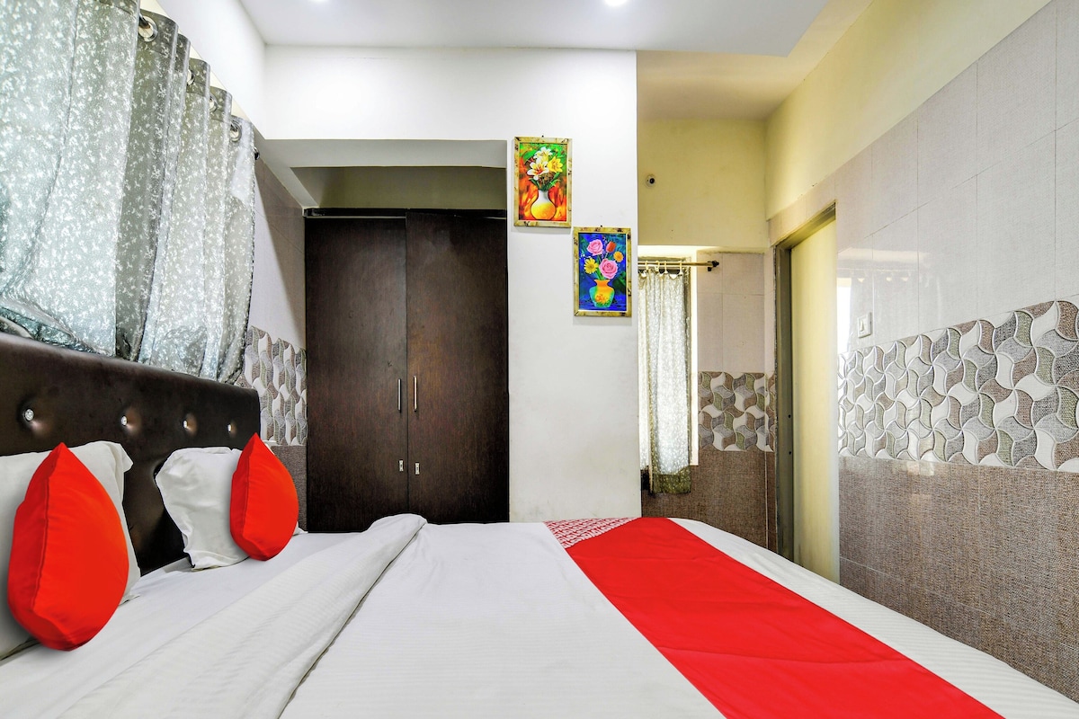 A hotel room with a bed, a wardrobe, and a bathroom visible through an open door.
